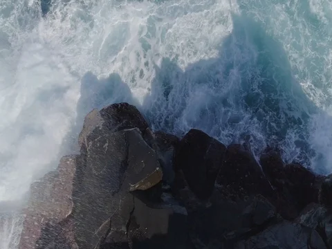 4k drone topshot of powerful waves hitting  wet big rocks Stock Footage 83871060