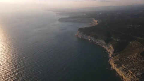 4K drone video of rocky cliffs and crystal clear sea at sunset Stock Footage 237343069