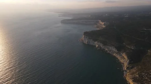 4K drone video of rocky cliffs and crystal clear sea at sunset Stock Footage 237343339