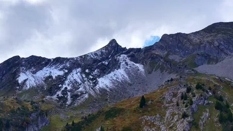 4K Drone View Alpine Peak With Snow And Rocky Slopes Fotos de archivo