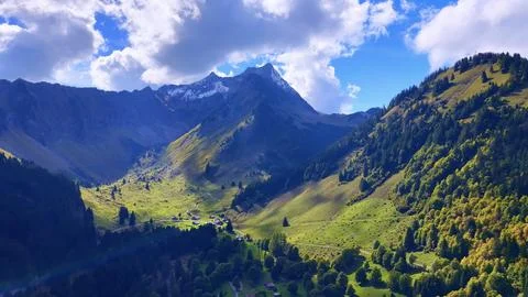 4K Drone View Alpine Valley With Chalets And Mountain Peaks Fotos de archivo