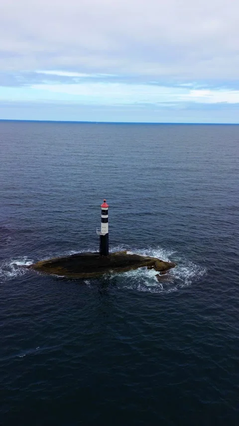 4K Drone View of Lighthouse on Rocky Isle Surrounded by Calm Sea in Norway Stock Footage 296017555