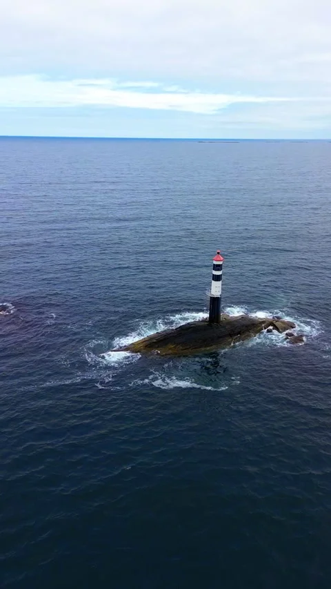 4K Drone View of Lighthouse on Rocky Isle Surrounded by Calm Sea in Norway Stock Footage 296017597