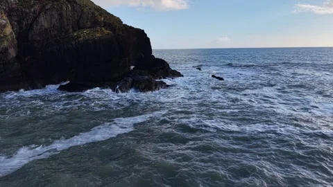 4K drone view of ocean waves near rocky coastal cliff Stock Footage 333707676