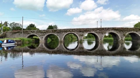 4K Drone View of Stone Arched Bridge Over Calm River Stockbeeldmateriaal 333335942