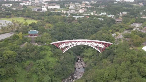 4K Dynamic Drone Shot to Seonim Bridge (선임교) above Cheonjeyeon Waterfalls, Jeju Stock Footage 143881745
