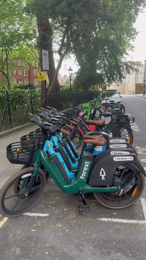 4K Editorial Panning Shot Of Forest And Lime E-Bikes In London Park Area Vídeos de archivo 335831921