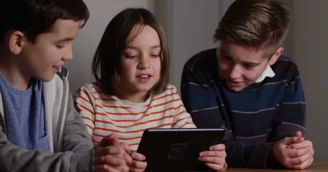 4k, Elder brothers watch their little sister play games on a digital tablet. Slo Stock Footage 61372982