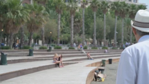 4K elderly couple walking on the beach with palm trees in the background Stock Footage 90803423