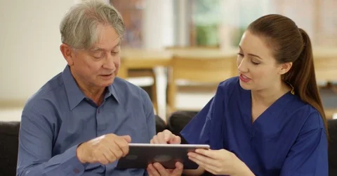 4K Elderly man learning how to use computer with help from home support nurse Stock Footage 81474553