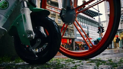 4k: Electric E scooters at the road cross ready for ride in rainy Berlin Stock Footage 132177599