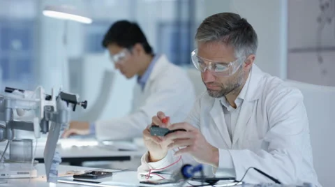 4K Electronics engineers working in lab building & testing electronic devices Stock Footage