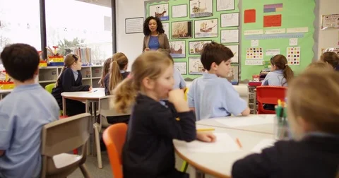 4K Elementary school children listening attentively to the teacher in classroom Stock Footage 74259789