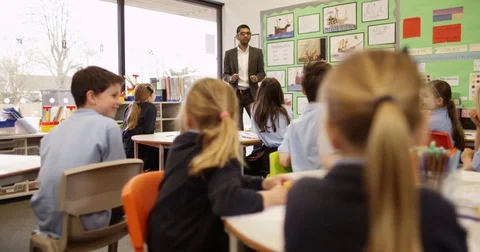 4K Elementary school children listening attentively to the teacher in classroom Stock Footage