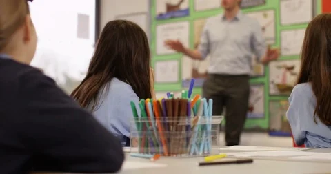 4K Elementary school children listening attentively to the teacher in classroom Stock Footage