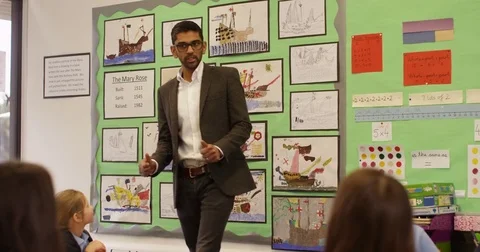 4K Elementary school children listening attentively to the teacher in classroom Stock Footage 74264568