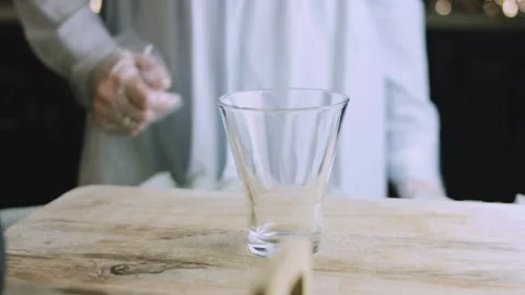 4K Empty Clear Measuring Glass on a Rustic Wooden Counter with a Baker Softly Stock Footage 342112916