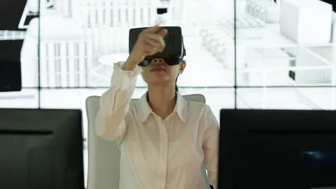 4K Engineer wearing VR viewer at desk with animated graphic in background Video stock 75962626