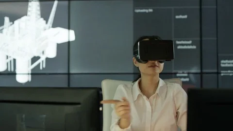 4K Engineer wearing VR viewer at desk with animated graphic in background Video stock 75962946