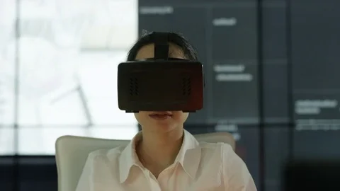 4K Engineer wearing VR viewer at desk with animated graphic in background Video stock 75963618