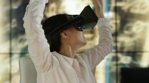 4K Engineer wearing VR viewer at desk with animated graphic in background Video stock 75965567