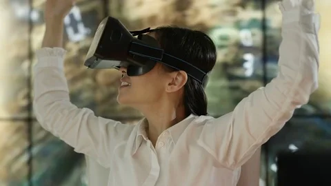 4K Engineer wearing VR viewer at desk with animated graphic in background Video stock 75965770