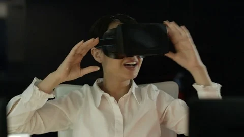 4K Engineer wearing VR viewer at desk with animated graphic in background Video stock 75966999