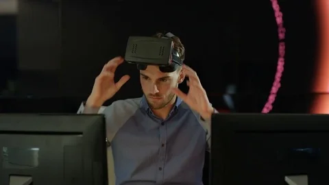 4K Engineer wearing VR viewer at desk with animated graphic in background Video stock 75968115