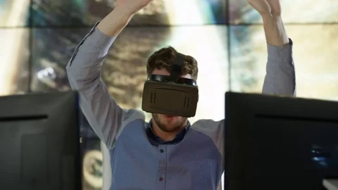 4K Engineer wearing VR viewer at desk with animated graphic in background Video stock 75969611