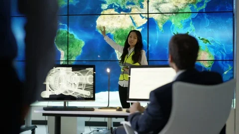 4K Engineering team in discussion looking at world map graphic on video wall 動画素材 75941267