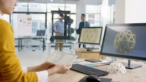 4K Engineers looking at prototype in a 3D printer &amp; checking design on computer. Stock Footage 73871065