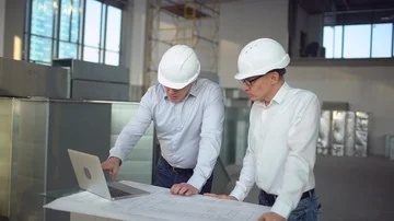 4K Engineers or architects having a discussion at construction site. airduct of Stock Footage 85877892