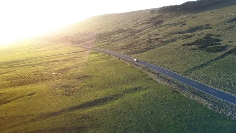 4k Epic aerial car tracking shot along peaceful road towards sunset Stock Footage 105854673