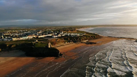 4k Epic aerial flying towards coastal village at sunset, ruins and waves Video stock 89238996