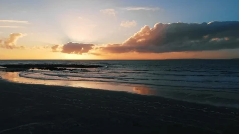 4k epic sunset aerial low over beach and waves towards ocean sunset 動画素材 89232428