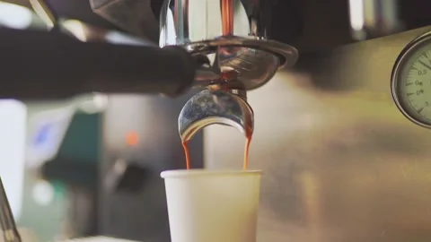 4k, espresso coffee is pouring from the coffee machine into a white paper cup Stockbeeldmateriaal 170189201
