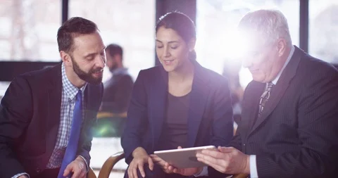 4K Executive business team of mixed ages discussing data on digital tablet Stock Footage 104633981