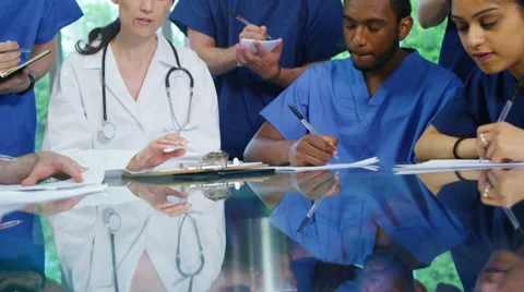 4K Experienced doctor in discussion with younger medical staff Stock Footage