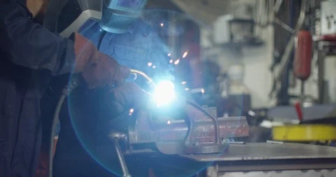 4K Experienced engineer &amp; young apprentice welding metal &amp; smiling at camera Video stock 111637183
