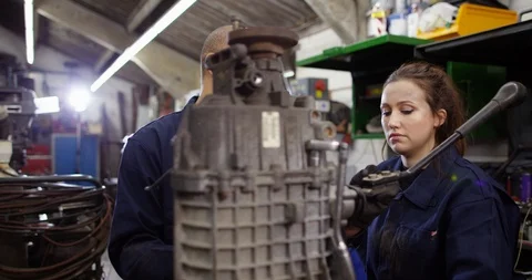 4K Experienced mechanic explaining automotive repairs to female apprentice Stock Footage 103054098