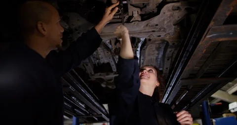 4K Experienced mechanic working with young female apprentice in the workshop Stock Footage 103048586