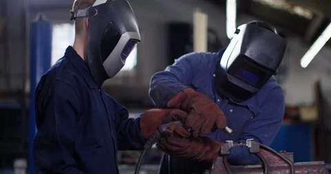4K Experienced welder &amp; young apprentice working together in workshop Stock Footage 113100358