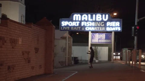 4K EXT NIGHT handheld pan Malibu with a car traffic and dancing man Stock Footage 73115315