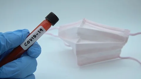 4K, Face mask and test tube with infected blood sample for virus COVID-19.-Dan Stock Footage 125601616