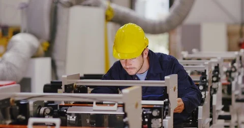 4K Factory engineer checking printing machines &amp; looking up to smile at camera Stock Footage 101994426