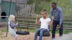 Parents Push Their Child On A Swing And Stock Video Pond5