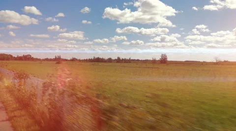4k - Fast moving camera near a field and blue sky with light leaks Video stock 67406727