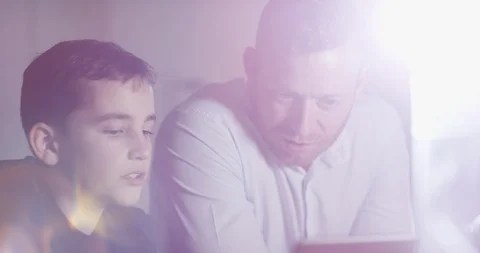 4K Father spending time with son at home, web browsing or helping with homework Stock Footage 107694088