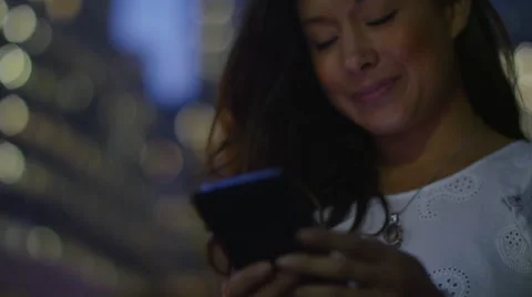 4K Female at dusk using her phone in the city cheerfully, shot on RED EPIC Stock Footage 53131142