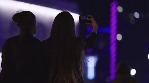 4K Female friends pull silly faces during a selfie in the city at night. Urban Stock Footage 94831275